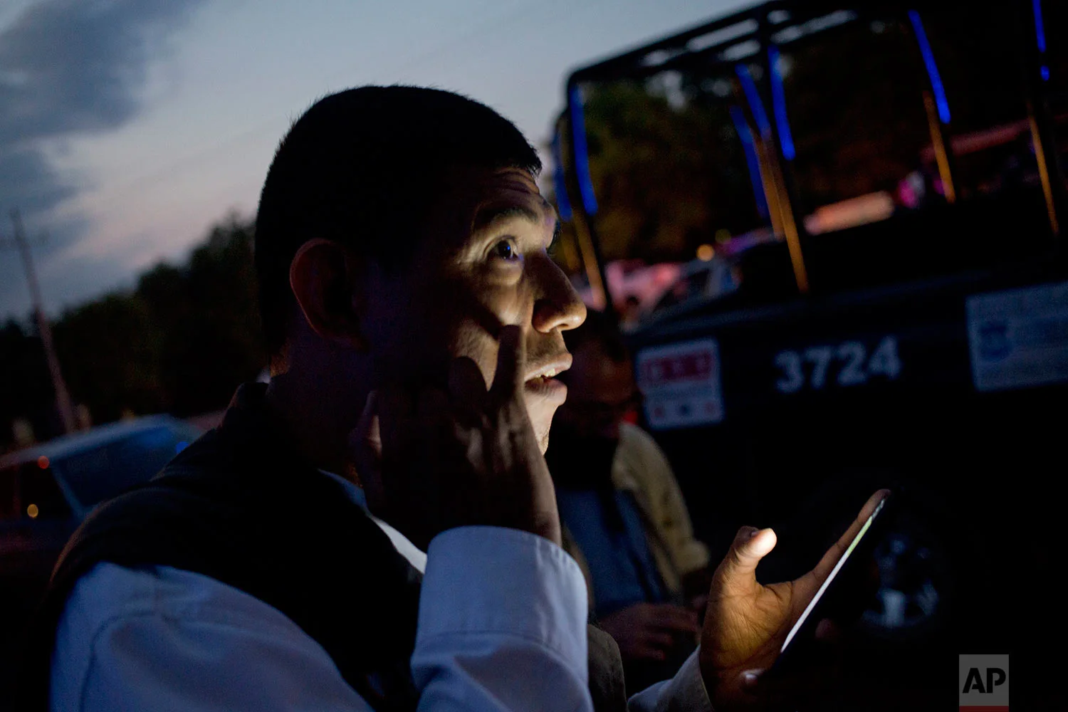 In this early, June 29, 2017 photo, multimedia journalist Ernesto Martinez, known as "El Pepis," from the local online news website "Linea Directa," reports from his cellphone at the site where three bodies were found in Navolato, on the outskirts of Culiacan, Sinaloa state, Mexico. As bodies pile up across the country, more and more of them are journalists: at least 25 since President Enrique Pena Nieto took office in December 2012, according to the Committee to Protect Journalists, and 589 under federal protection after attacks and threats. (AP Photo/Enric Marti)