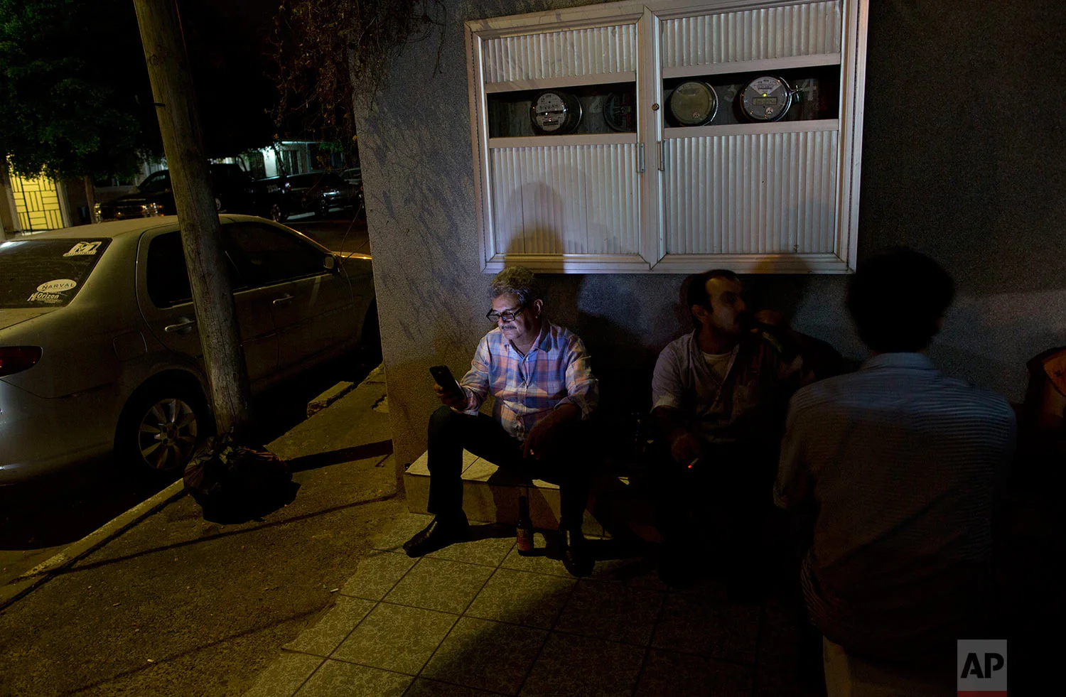 In this June 27, 2017 photo, a family from the United States visits the shrine of Jesus Malverde, the so-called narco-saint revered by many of Mexico's drug traffickers, in Culiacan, Sinaloa state, Mexico. In Sinaloa people are shot dead in the street every day and the cemetery is filled with ornate, two-story mausoleums for drug kings that are larger than many homes for the living. (AP Photo/Enric Marti)
