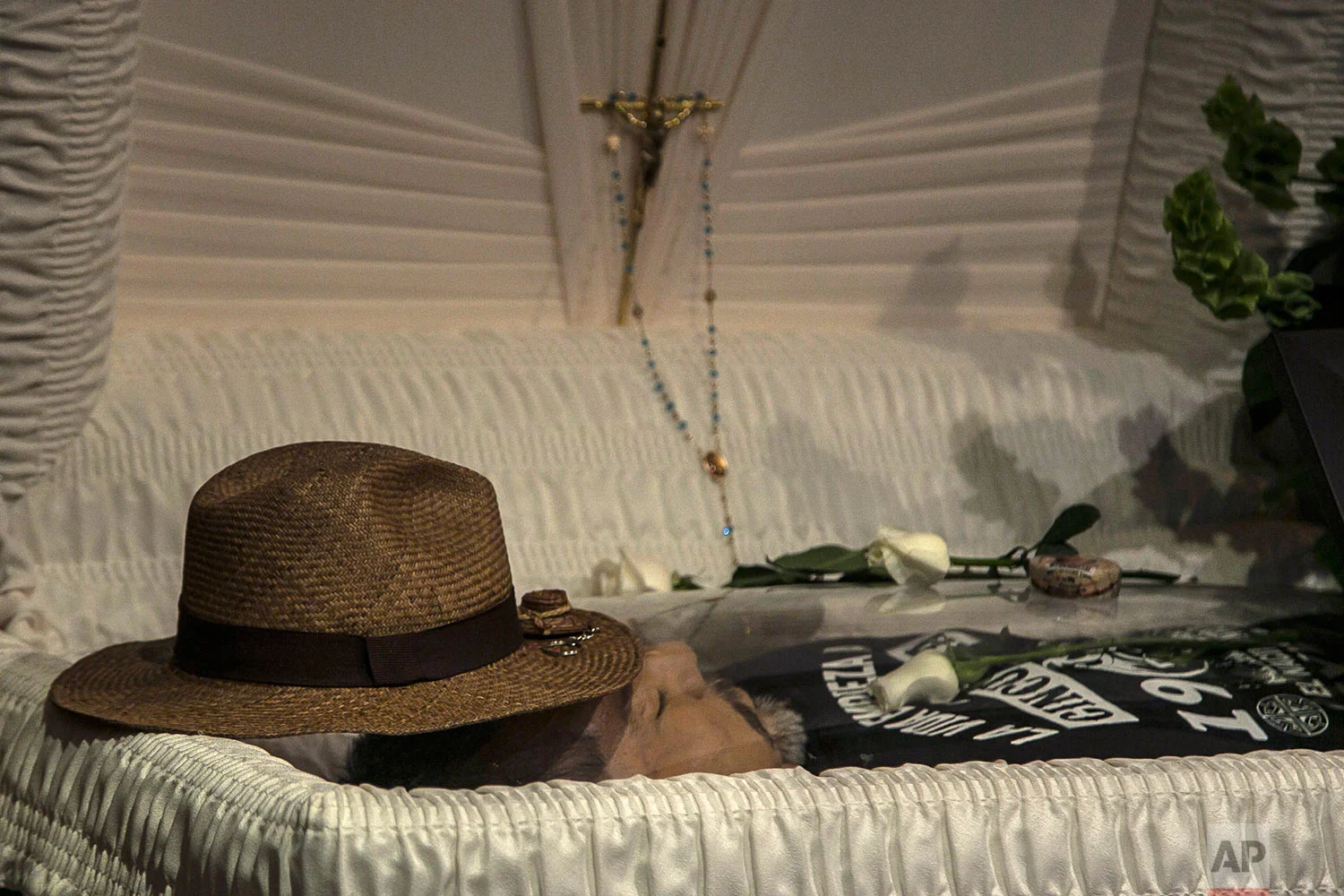 In this May 16, 2017 photo, the hat of slain journalist Javier Valdez lays on his forehead inside a funeral home before his wake begins in Culiacan, Mexico. “The greatest error is to live in Mexico and to be a journalist,” wrote Valdez, a legend in Mexico and abroad, whose killing is seen as a milestone in Mexican violence against journalists. Valdez, 50, left a wife and two adult children. There have been no arrests _ which is no surprise to the national press corps. (AP Photo/Rashide Frias)