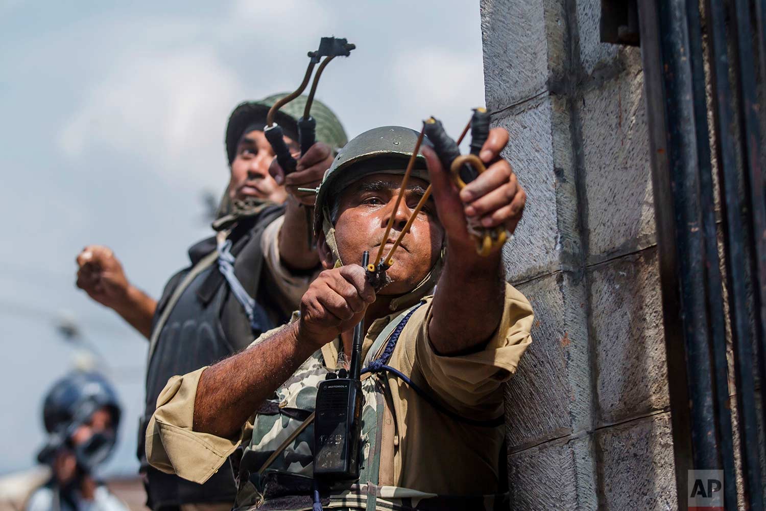  Indian paramilitary soldiers use slingshots to shoot glass marbles at Kashmiri protesters in Srinagar, Indian controlled Kashmir, Friday, Aug. 4, 2017. (AP Photo/Dar Yasin) 