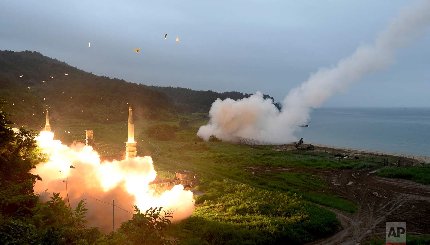 In this photo provided by South Korea Defense Ministry, South Korea's Hyunmoo II Missile system, left, and a U.S. Army Tactical Missile System, right, fire missiles during a combined military exercise between the two countries against North Korea at an undisclosed location in South Korea, Saturday, July 29, 2017. (South Korea Defense Ministry via AP)