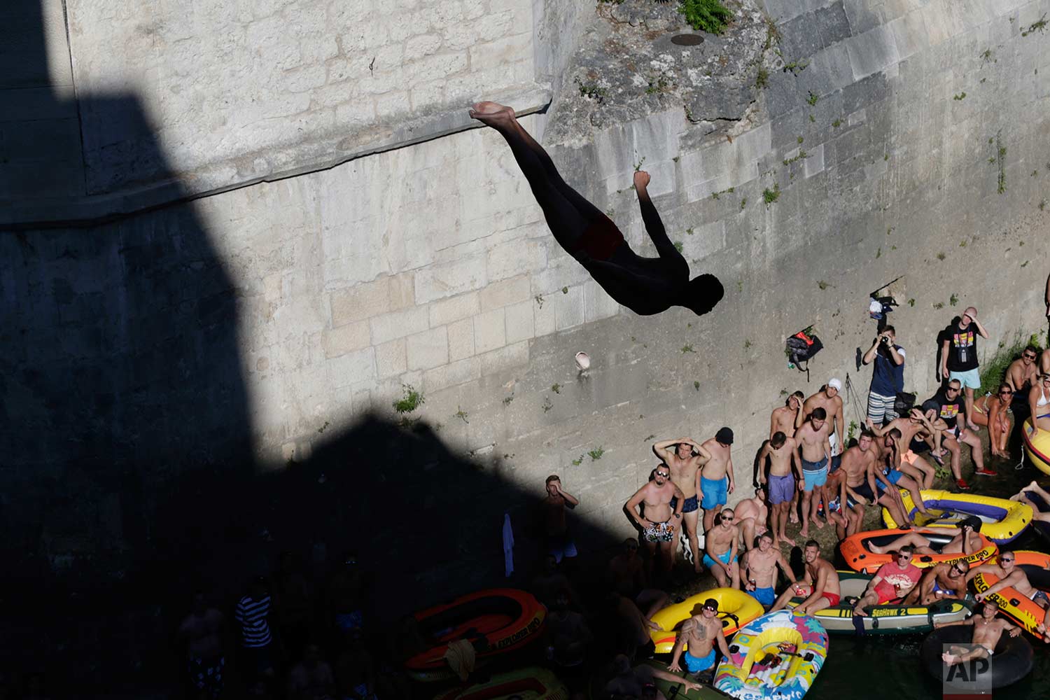  Spectators watch as a diver jumps from the Old Mostar Bridge during 451th traditional annual high diving competition, in Mostar, Bosnia, 140 kilometers (87 miles) south of the capital Sarajevo, Sunday, July 30, 2017. (AP Photo/Amel Emric) 