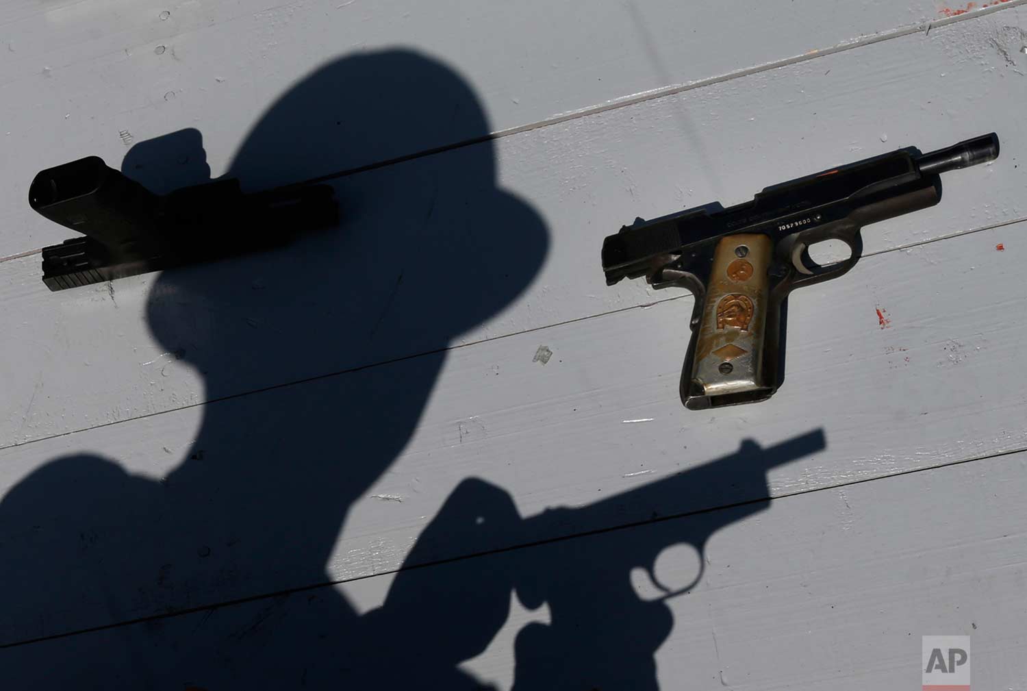  A Mexican Army soldier shows a set of hand guns sporting a gold plated grips, part of a lot of weapons slated for destruction in Mexico City, Tuesday, Aug. 1, 2017. (AP Photo/Marco Ugarte) 