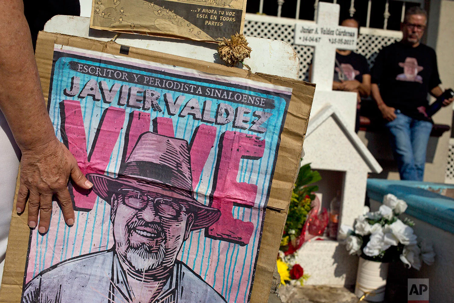 In this July 1, 2017 photo, relatives of slain journalist Javier Valdez, co-founder of Riodoce, stand at a memorial set up at the spot where he was murdered in Culiacan, Sinaloa state, Mexico. On the morning of May 15, Valdez left his Riodoce office and managed to drive just a couple of blocks before his red Toyota Corolla was stopped by two men; he was forced out of his car and shot 12 times. (AP Photo/Enric Marti)