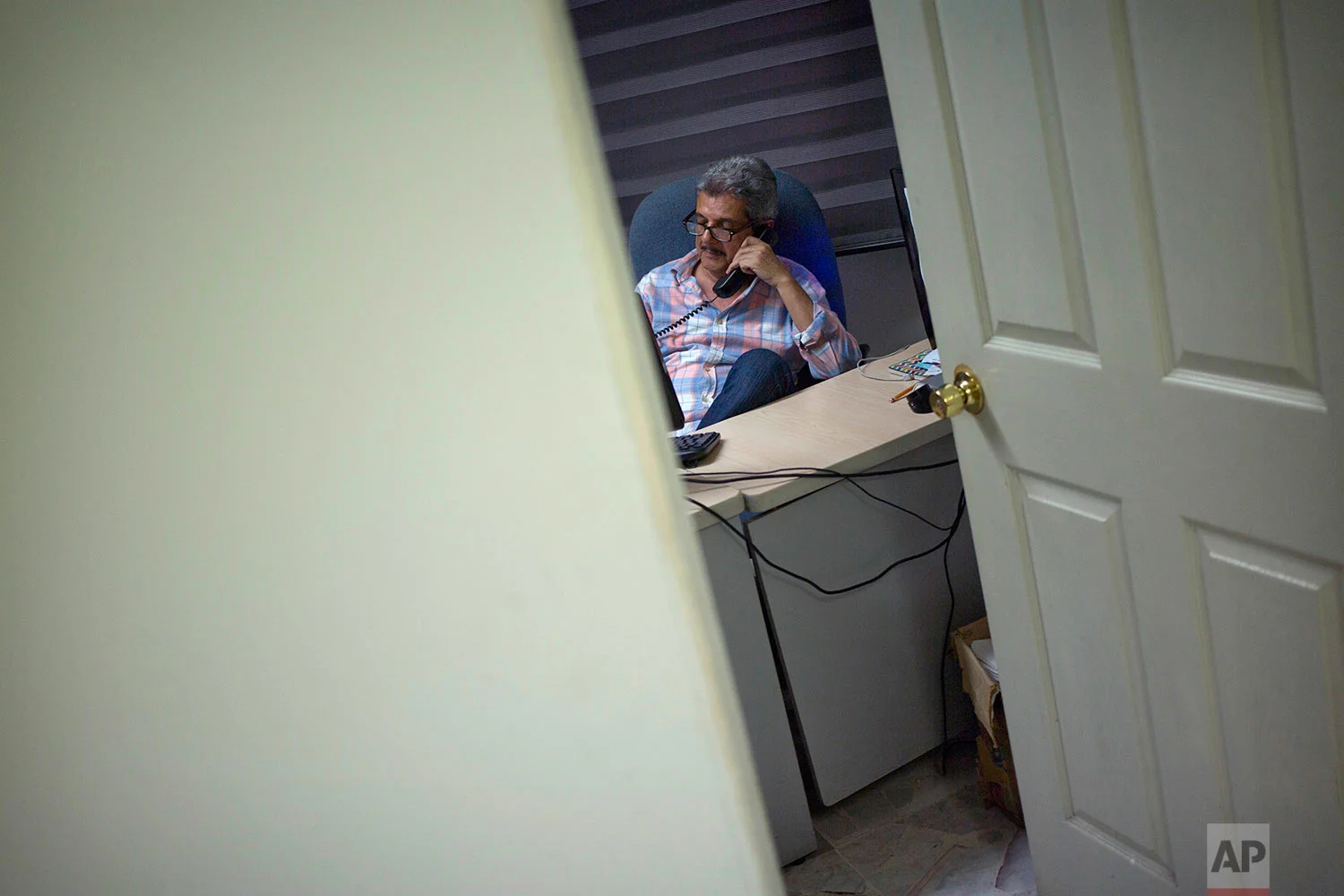 In this June 30, 2017 photo, Ismail Bojorquez, 60, co-founder and director of Riodoce, speaks on the phone as he prepares the weekly edition at his office in Culiacan, Sinaloa state, Mexico. Bojorquez and slain journalist Javier Valdez joined three colleagues in creating the newspaper Riodoce. Over time the paper earned a reputation for brave and honest coverage. (AP Photo/Enric Marti)
