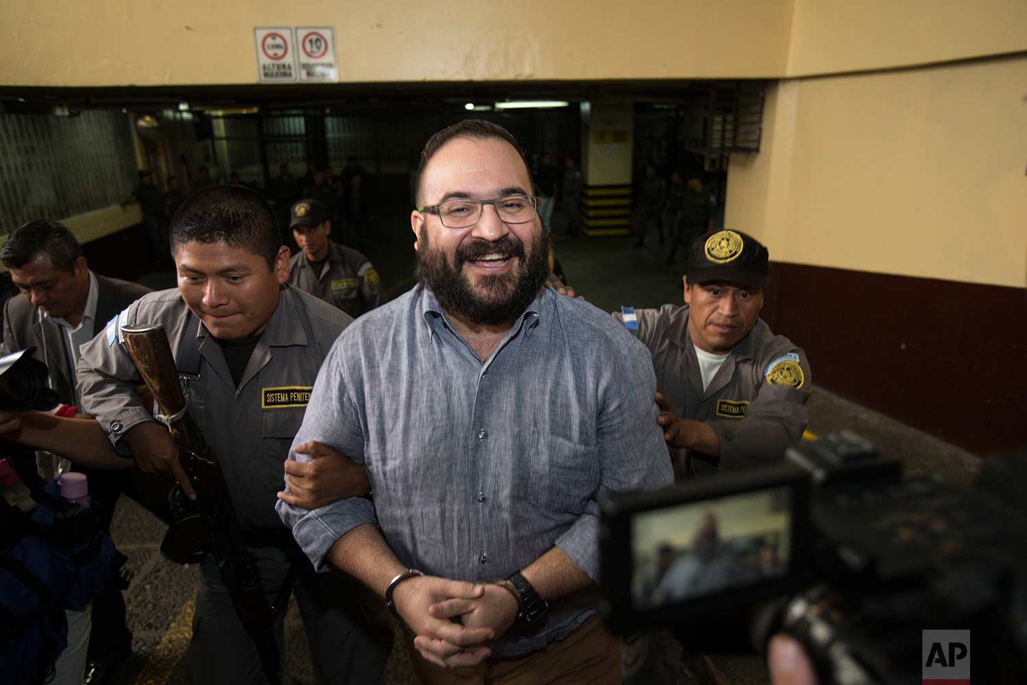 Mexico's former Veracruz state Gov. Javier Duarte smiles as he leaves court in handcuffs after a hearing in Guatemala City, Tuesday, July 4, 2017. (AP Photo/Moises Castillo)