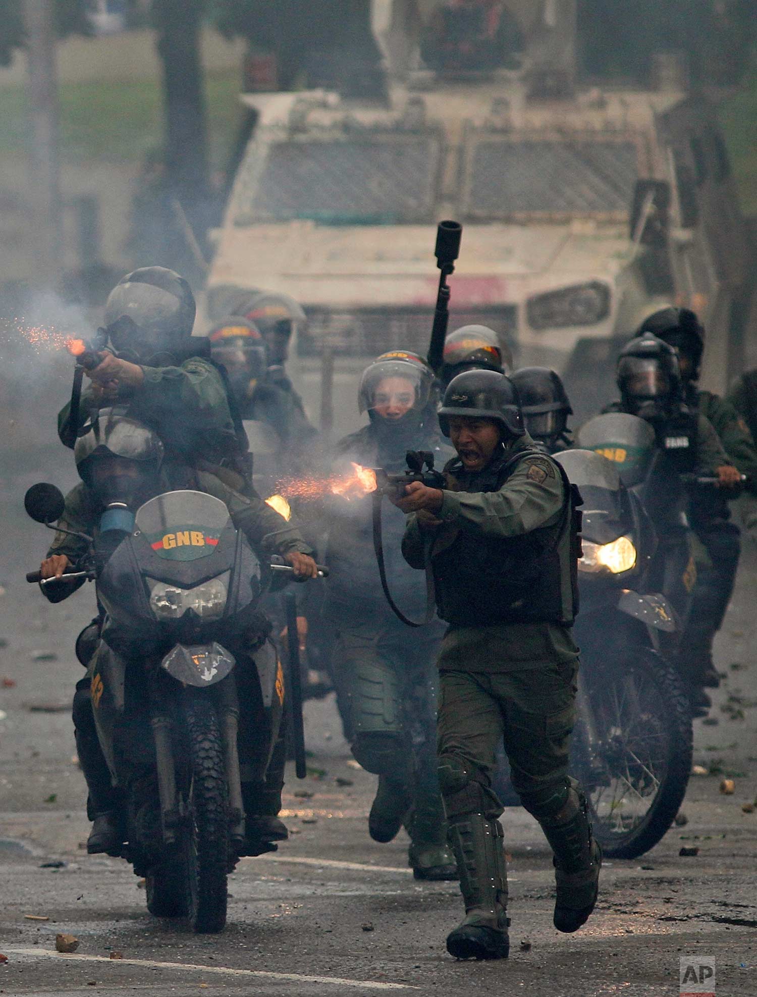 Bolivarian National Guards fire rubber bullets as they advance on anti-government demonstrators in Caracas, Venezuela, Friday, July 28, 2017, two days before the vote to begin the rewriting of Venezuela's constitution. (AP Photo/Ariana Cubillos)