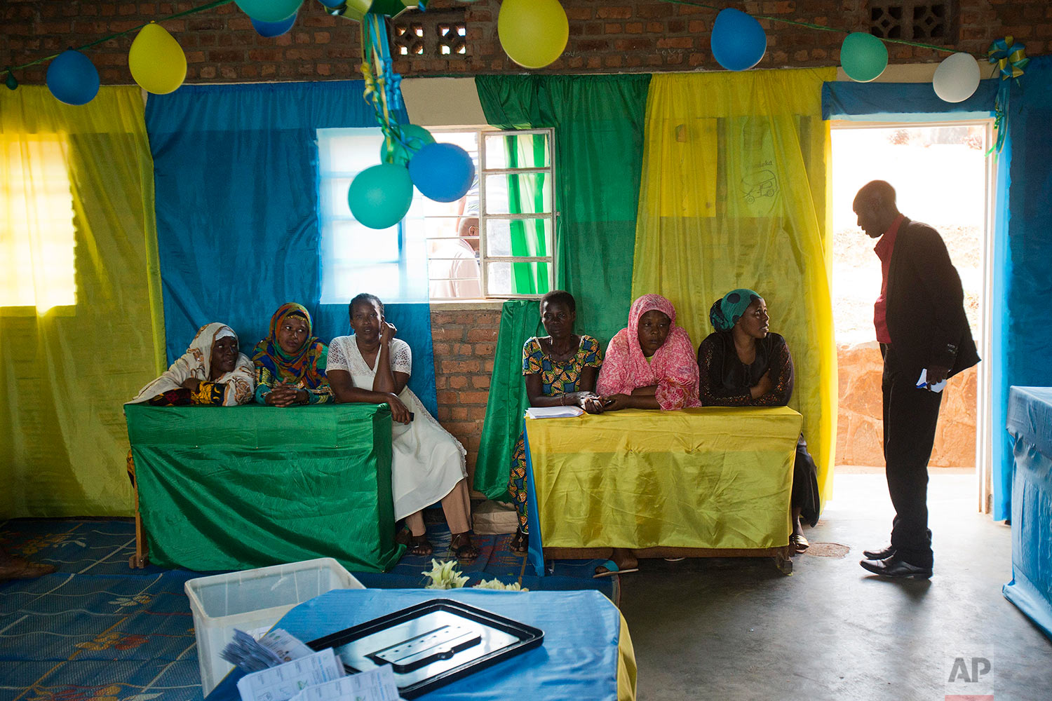 Observers watch as vote count starts in a polling station in Rwanda's capital Kigali Friday Aug. 4, 2017, for the presidential elections. Rwandans voted in an election Friday that the country's longtime president is widely expected to win, after the government disqualified all but three candidates. (AP Photo/Jerome Delay)