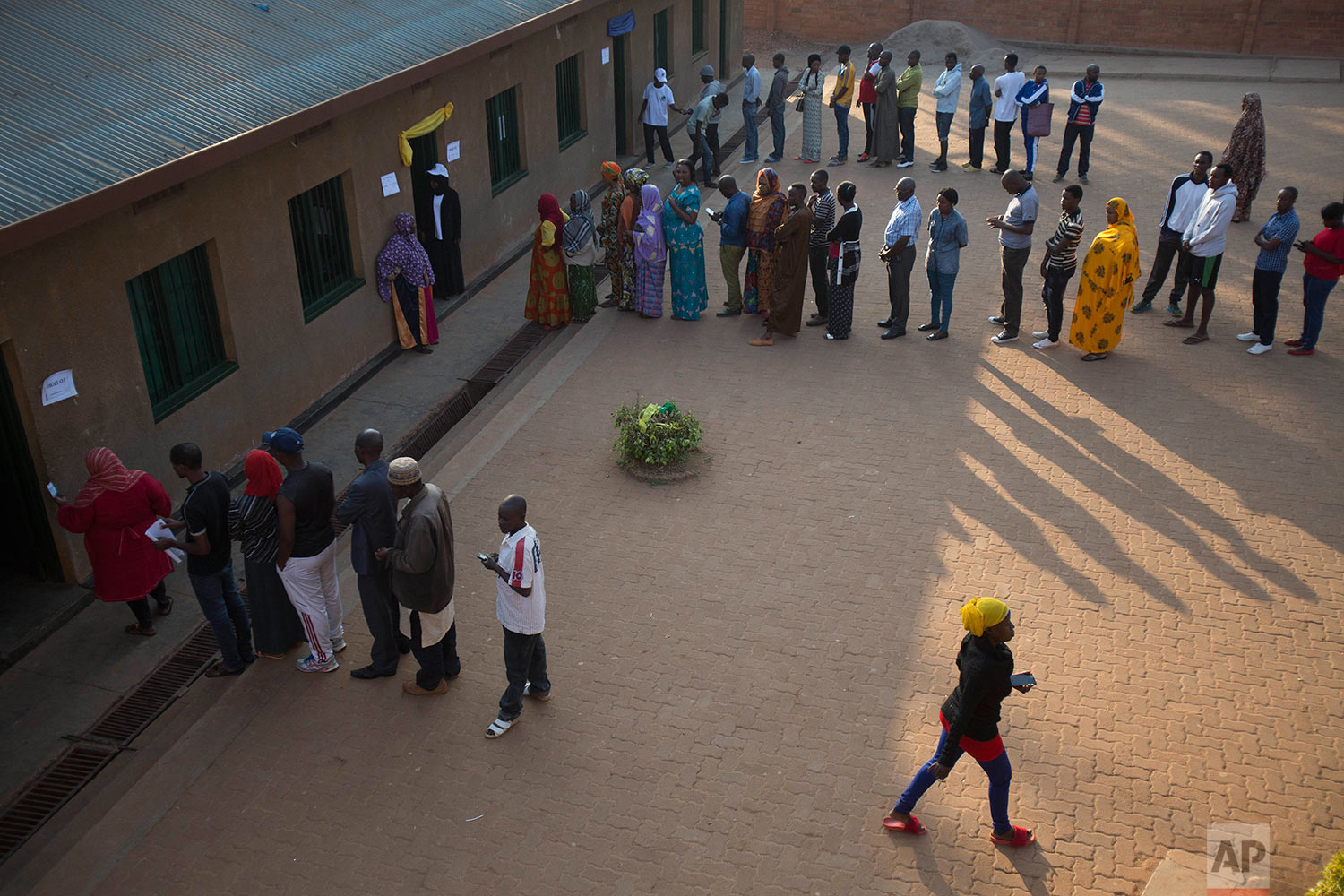  Rwandans line up to cast their vote for the presidential elections at a polling station in Rwanda's capital Kigali Friday, Aug. 4, 2017. Outgoing President Paul Kagame is widely expected to win another term after the government disqualified all but 