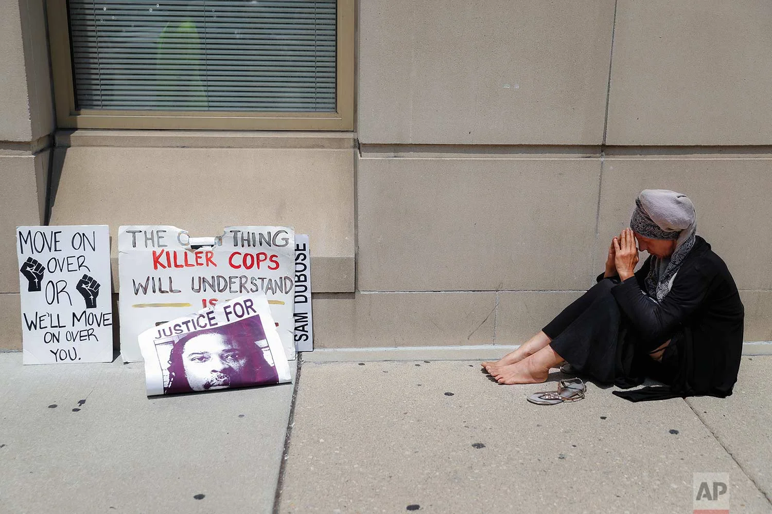  A protestor prays outside the offices of Hamilton County Prosecutor Joseph Deters following a news conference Tuesday, July 18, 2017, where Deters announced his decision to not pursue a third trial of former University of Cincinnati police officer R
