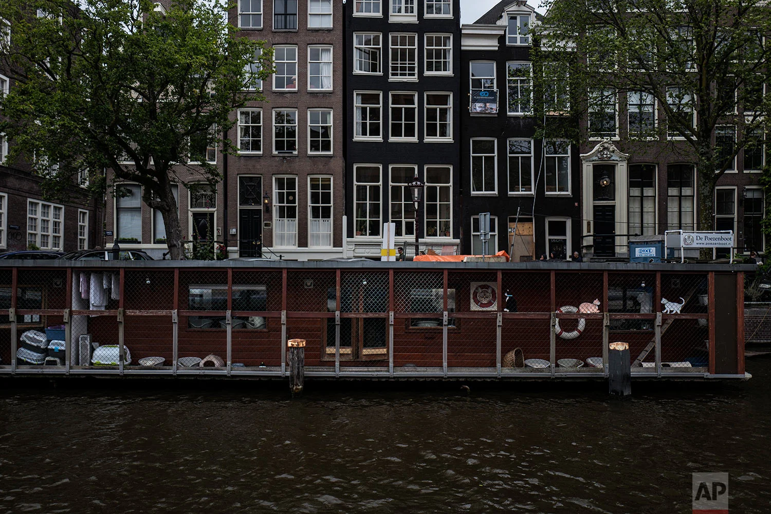  In this Thursday, Aug. 3, 2017 photo, people walk by the Catboat shelter in Amsterdam, Netherlands. (AP Photo/Muhammed Muheisen) 