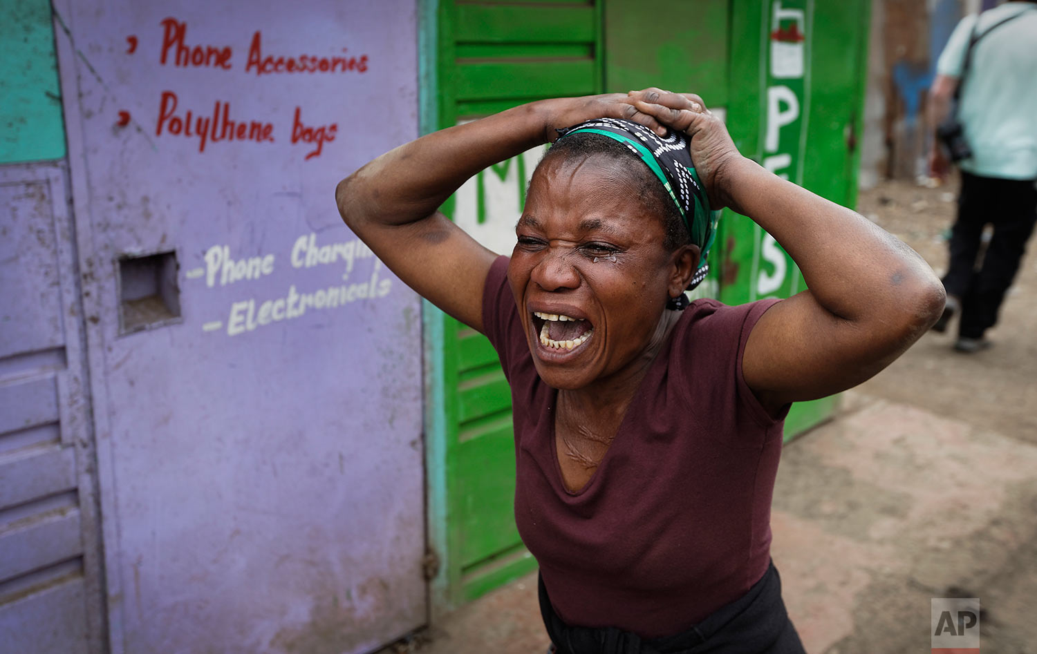 A relative wails near the body of a man who had been shot in the head and who the crowd claimed had been shot by police, in the Mathare area of Nairobi, Kenya ,Wednesday, Aug. 9, 2017. Kenya's election took an ominous turn on Wednesday as violent protests erupted in the capital. (AP Photo/Ben Curtis)
