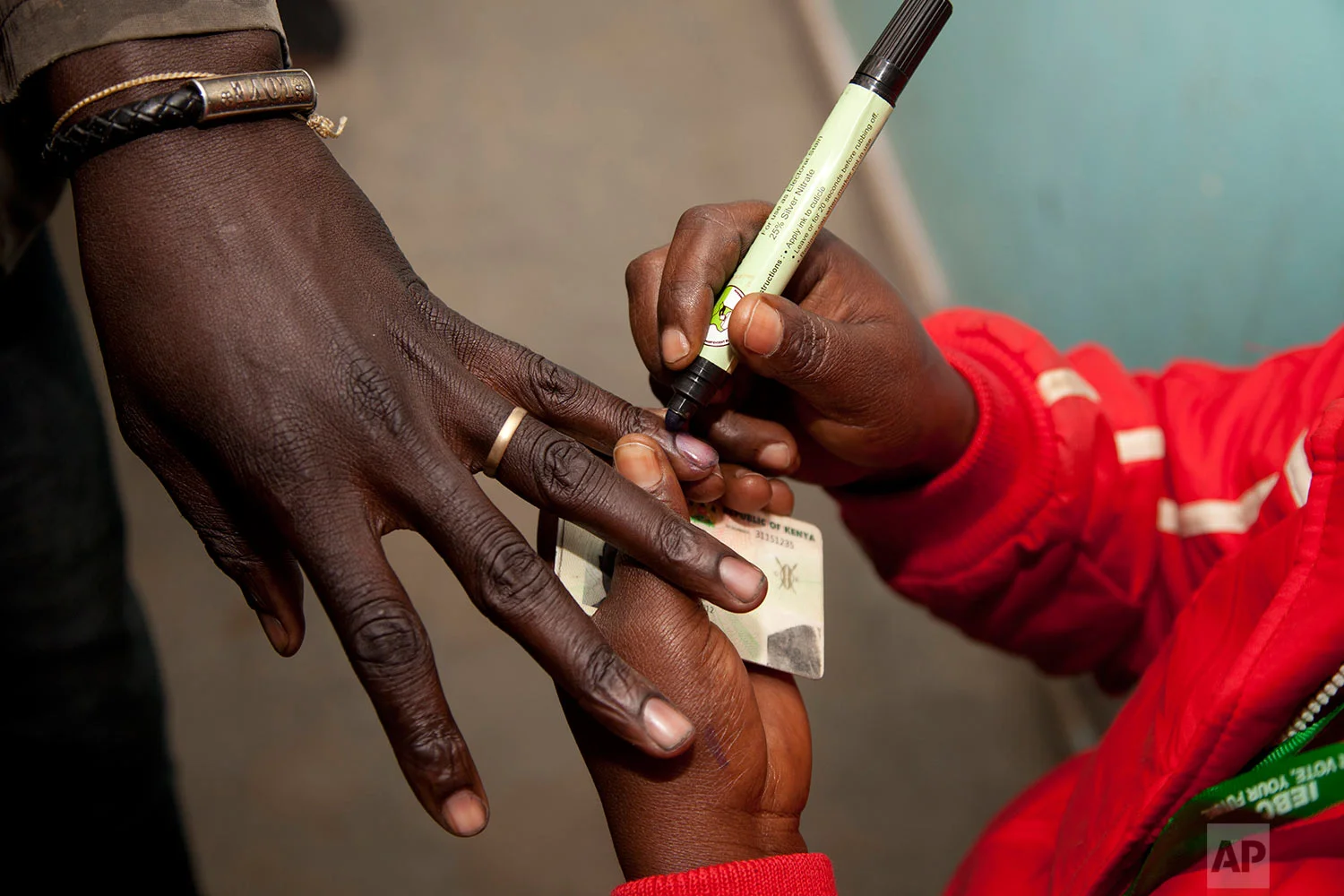 A polling official marks a voter's finger after casting his vote at a polling station in Nairobi, Kenya, Tuesday, Aug. 8, 2017. Kenyans are going to the polls to vote in a general election after a tightly fought presidential race between incumbent President Uhuru Kenyatta and main opposition leader Raila Odinga. (AP Photo/ Sayyid Abdul Azim)