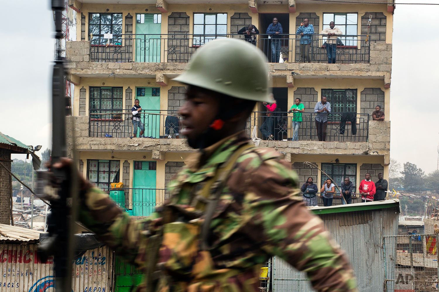  Residents watch from their balconies as Kenyan security forces chase supporters of Kenyan opposition leader and presidential candidate Raila Odinga who demonstrated in the Mathare area of Nairobi, Wednesday, Aug. 9, 2017. Odinga alleges that hackers