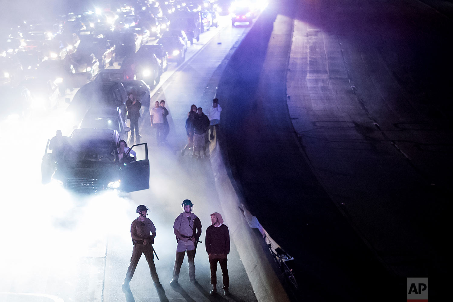  Police officers stand watch as protesters against racism block traffic on both directions of Interstate 580 in Oakland, Calif., Saturday, Aug. 12, 2017. (AP Photo/Noah Berger) 