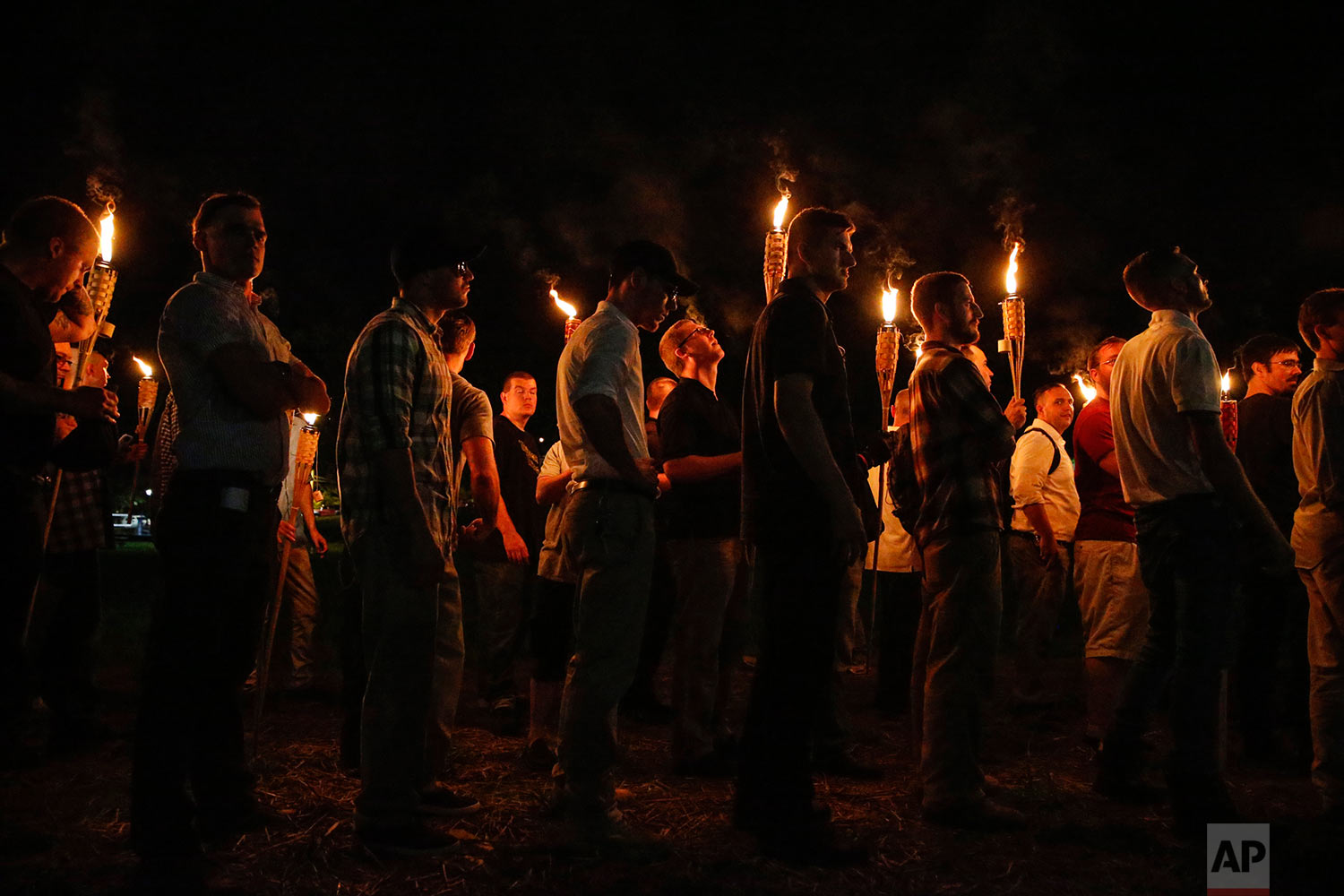 In this photo taken Friday, Aug. 11, 2017, multiple white nationalist groups march with torches through the UVA campus in Charlottesville, Va.   Hundreds of people chanted, threw punches, hurled water bottles and unleashed chemical sprays on each ot