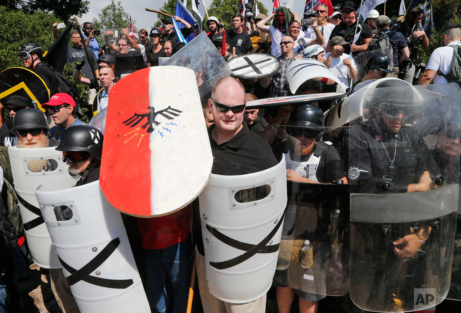  White nationalist demonstrators use shields as they guard the entrance to Lee Park in Charlottesville, Va., Saturday, Aug. 12, 2017. (AP Photo/Steve Helber) 
