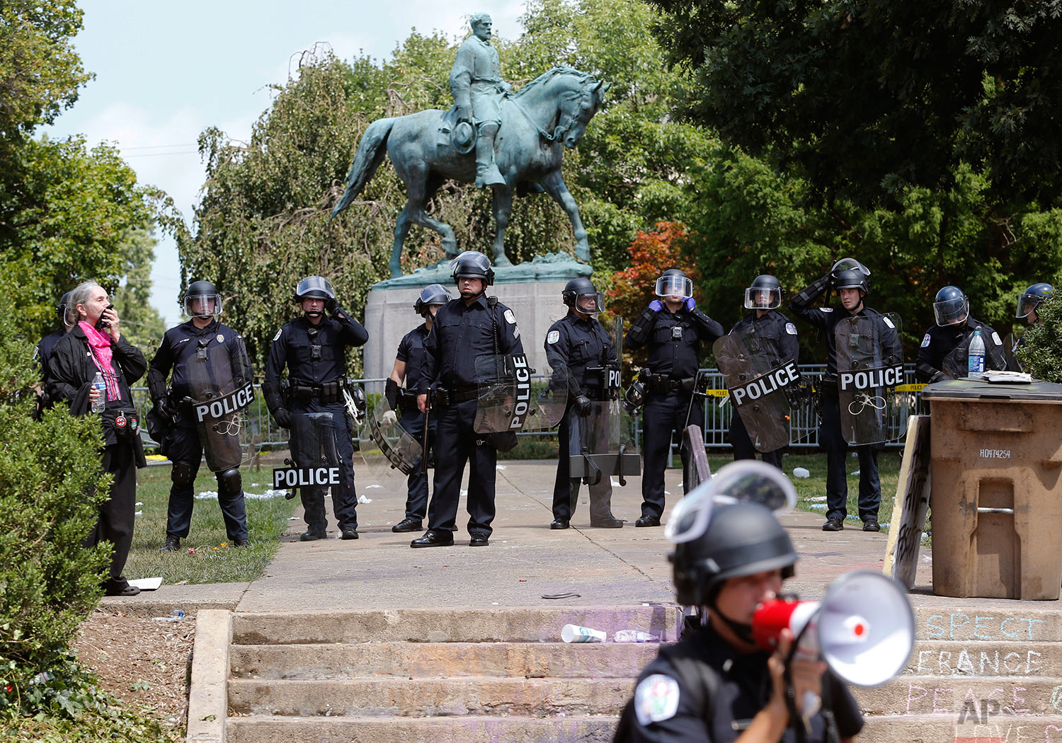  State Police in riot gear guard Lee Park after a white nationalist demonstration was declared illegal and the park was cleared in Charlottesville, Va., Saturday, Aug. 12, 2017.  Hundreds of people chanted, threw punches, hurled water bottles and unl