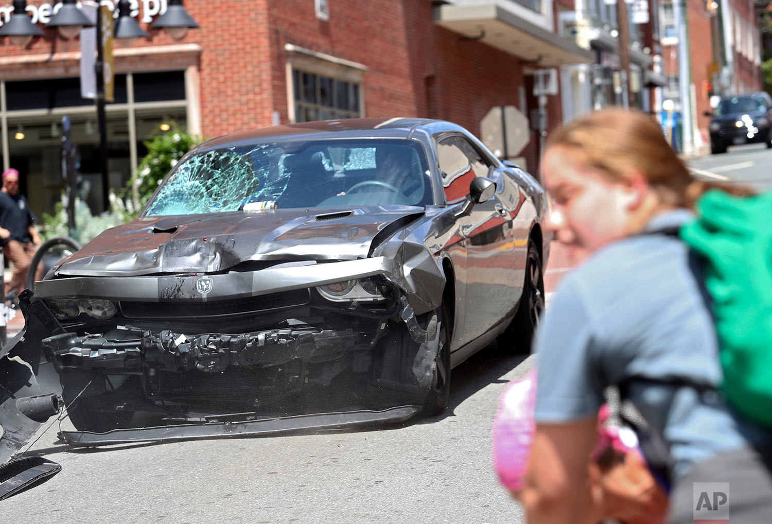  A vehicle reverses after driving into a group of protesters demonstrating against a white nationalist rally in Charlottesville, Va., Saturday, Aug. 12, 2017. (Ryan M. Kelly/The Daily Progress via AP) 