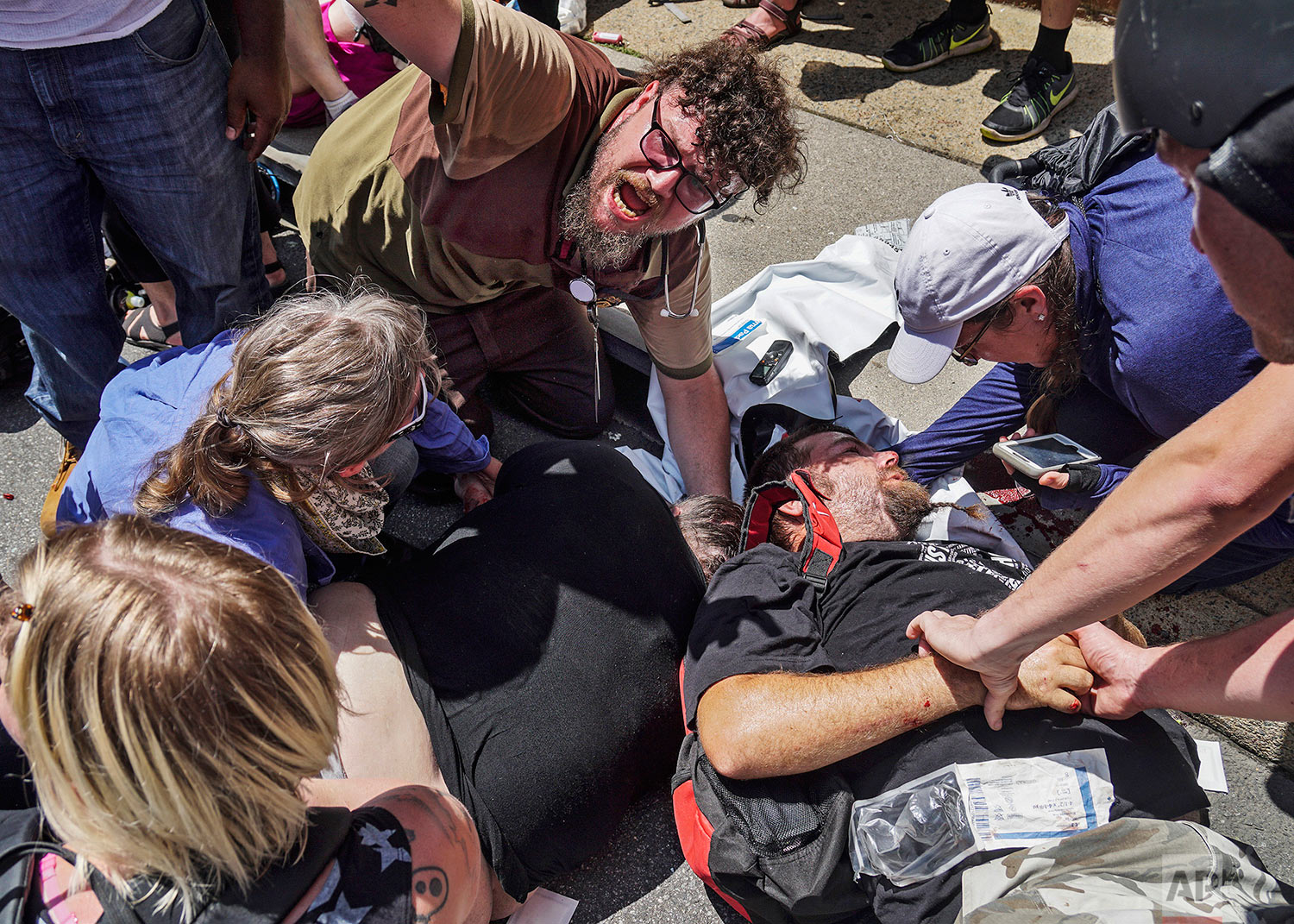 In this Saturday, Aug. 12, 2017 photo, responders work with victims at the scene where a man identified by police as James Alex Fields Jr., plowed a car into a crowd of people who had gathered to protest a white supremacist rally earlier in the day,