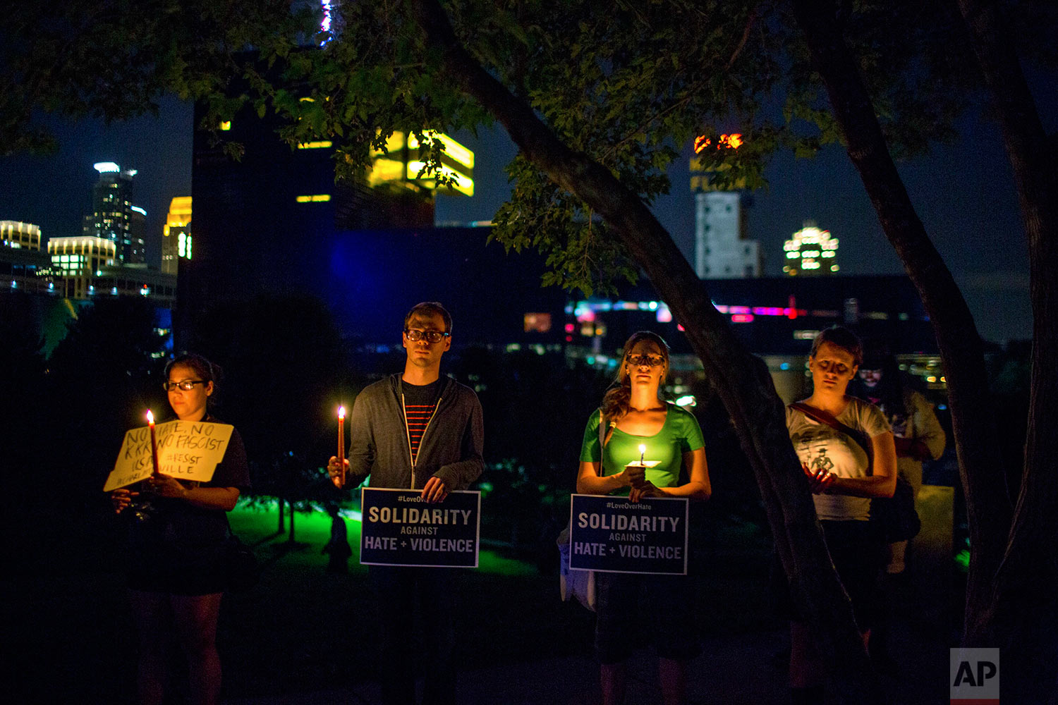  People stand atop a hill for a candlelight vigil in solidarity with Charlottesville, Virginia, counter-protesters at Gold Medal Park in Minneapolis on Saturday night, Aug. 12, 2017. (Courtney Pedroza/Star Tribune via AP) 