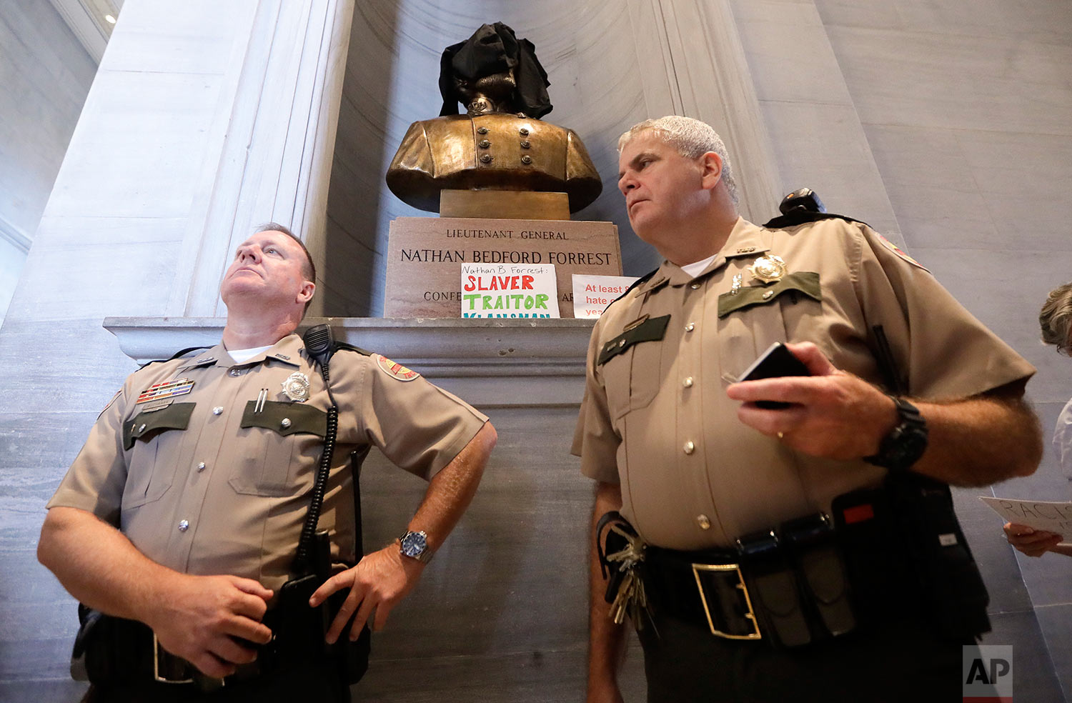  Tennessee State Troopers stand near a bust of Nathan Bedford Forrest after protesters covered it and placed signs in front of it Monday, Aug. 14, 2017, in Nashville, Tenn. Protesters called for the removal of the bust, which is displayed in the hall