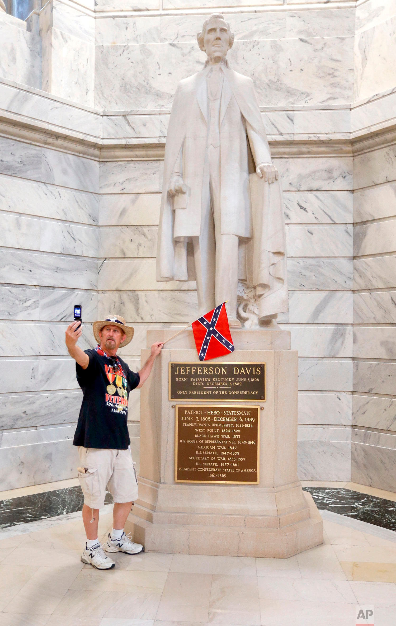  This photo taken July 24, 2017, shows James Hendrickson, Corbin, Ky., taking a "selfie" with the Jefferson Davis Statue following a rally in support of keeping the statue of Confederate president Jefferson Davis in the Capitol, held on the steps of 
