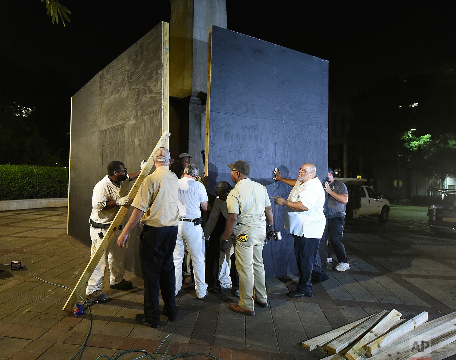  Birmingham city workers use plywood panels to cover the Confederate Monument in Linn Park, in Birmingham, Ala., Tuesday night, Aug. 15, 2017, on orders from Mayor William Bell. (Joe Songer  /AL.com via AP) 