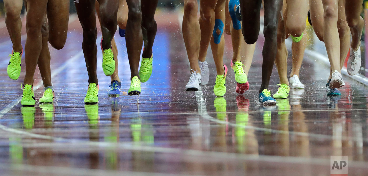  Competitors in the Women's 3000m Steeplechase are reflected on the wet track during the World Athletics Championships in London Wednesday, Aug. 9, 2017. (AP Photo/David J. Phillip) 