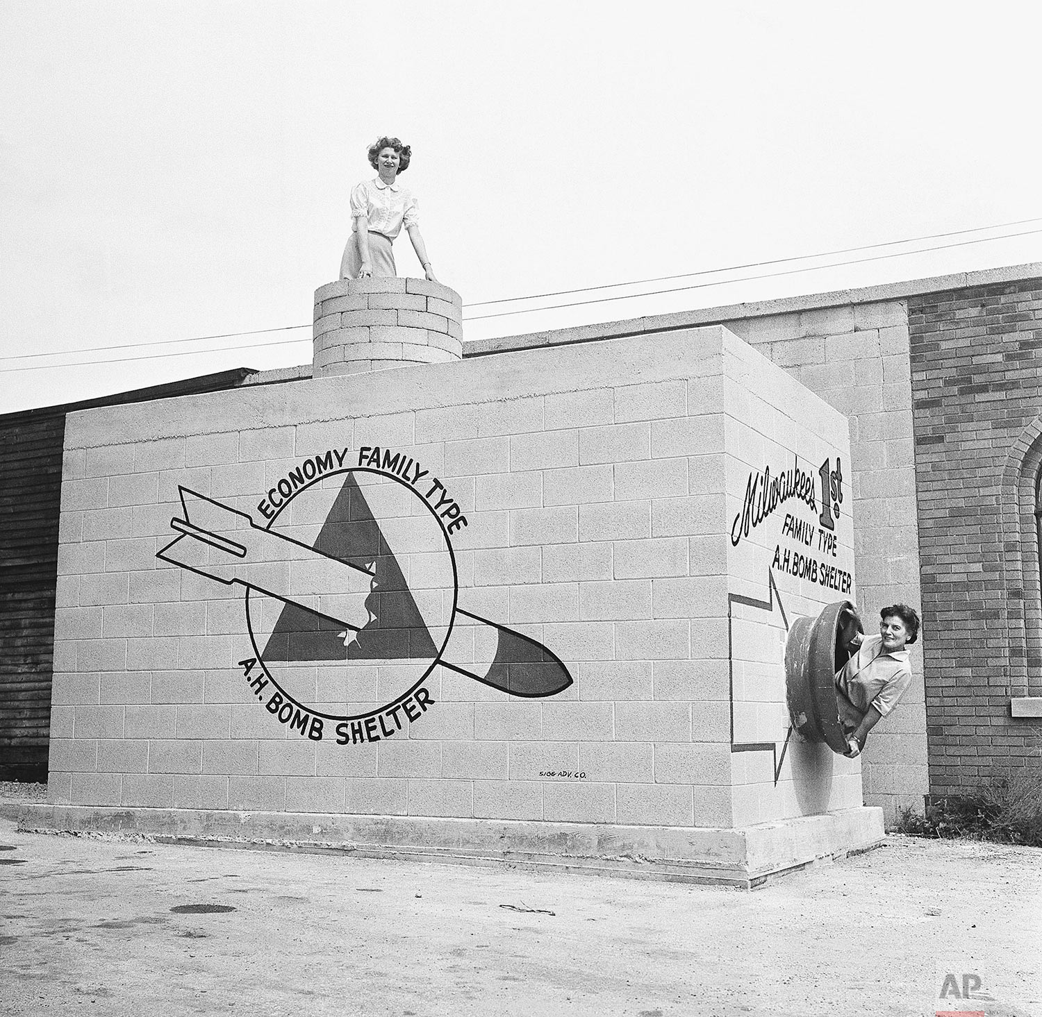 In this Sept. 12, 1958 photo, Beverly Wysocki, top, and Marie Graskamp, right, emerge from a new family-type bomb shelter on display in Milwaukee, Wis. (AP Photo)
