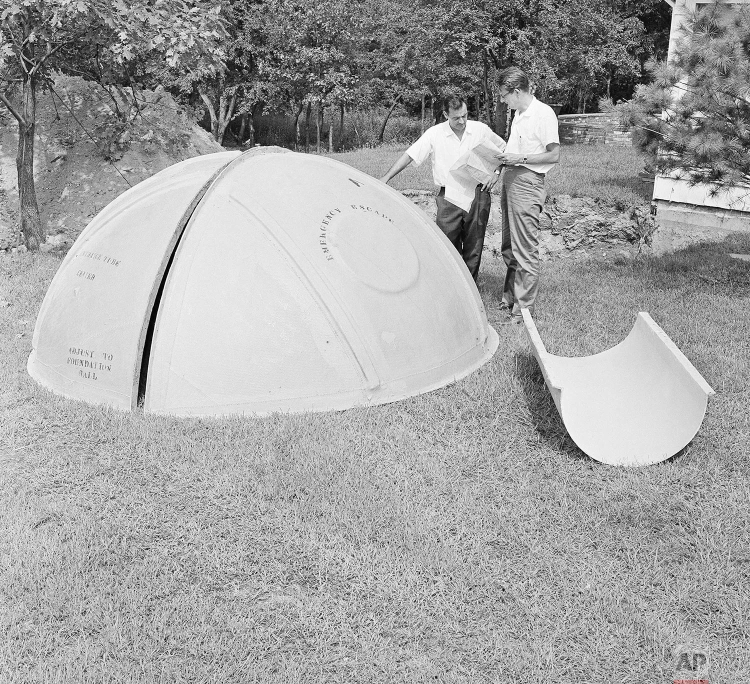 In this Sept. 7, 1961 photo, bomb shelter manufacturer engineers Vincent Carubia, left, and Eward Klein study specifications for a fiber glass dome shelter being installed on an estate in Locust Valley, N.Y. (AP Photo)