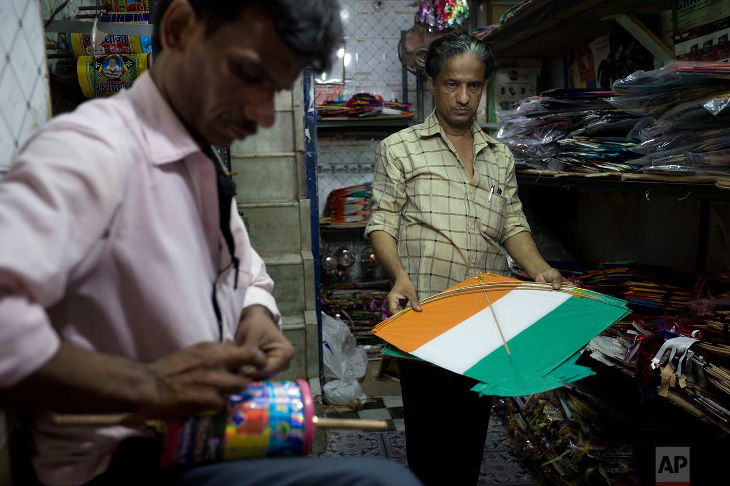  In this Tuesday, Aug. 15, 2017 photo, a kite seller holds a kite to hand over to a customer on Independence Day in the old quarters of New Delhi, India. (AP Photo/Tsering Topgyal) 