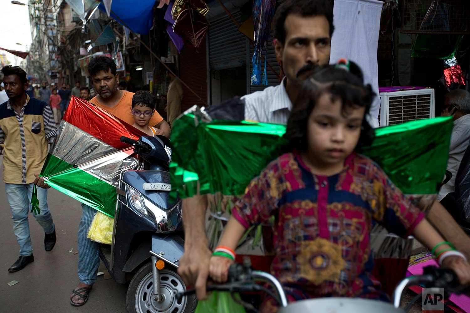  In this Tuesday, Aug. 15, 2017 photo, Indians ride motorbikes carrying kites to fly on Independence Day in the old quarters of New Delhi, India. (AP Photo/Tsering Topgyal) 