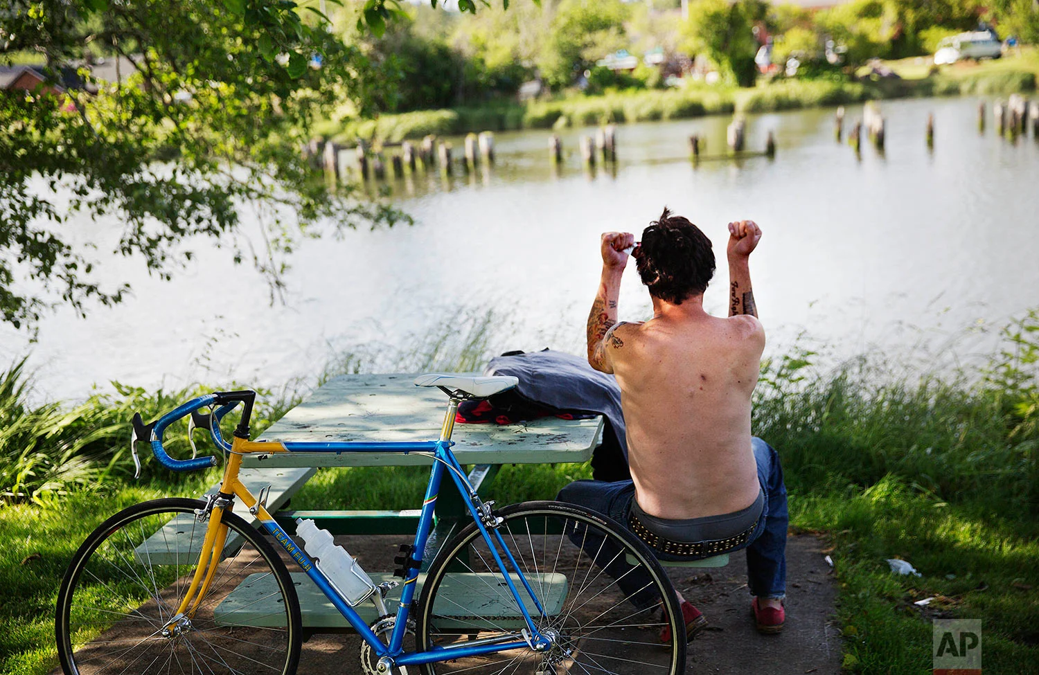 A man shouts across the Wishkah River while incoherently talking to himself at Kurt Cobain Memorial Park in Aberdeen, Wash., Tuesday, June 13, 2017. Grays Harbor County lands near the top of all the lists no place wants to be on: drugs, alcohol, early death, child abuse, runaway rates of welfare that pull some out of poverty but trap others in a cycle of dependency. (AP Photo/David Goldman)