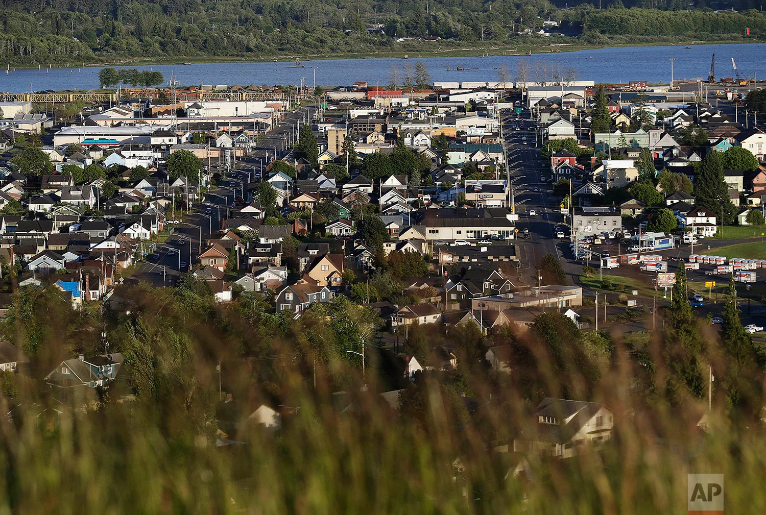 Aberdeen, Wash., is seen along the Chehalis River Friday, June 16, 2017. Aberdeen was built as a boom town at the turn of the 20th century. Its spectacular landscape, the Chehalis River carves through tree-topped hills to the harbor, offered ships easy access to the Pacific Ocean. Millionaire lumber barons built mansions on the hills. There were restaurants and theaters and traffic that backed up as the drawbridge leading into town seesawed up and down for ship after ship packed with logs and lumber. Now that drawbridge pretty much stays put. (AP Photo/David Goldman)
