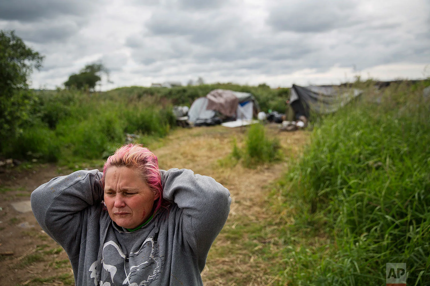Misty Micheau Bushnell looks over the memorial marking the spot where her boyfriend Shawn Vann Schreck died two days before in a homeless encampment where they live along the river in Aberdeen, Wash., Wednesday June 14, 2017. Bushnell, said his death shook her so much she thinks she's ready to move away, someplace inside, and she hopes her methamphetamine addiction won't follow her there. (AP Photo/David Goldman)