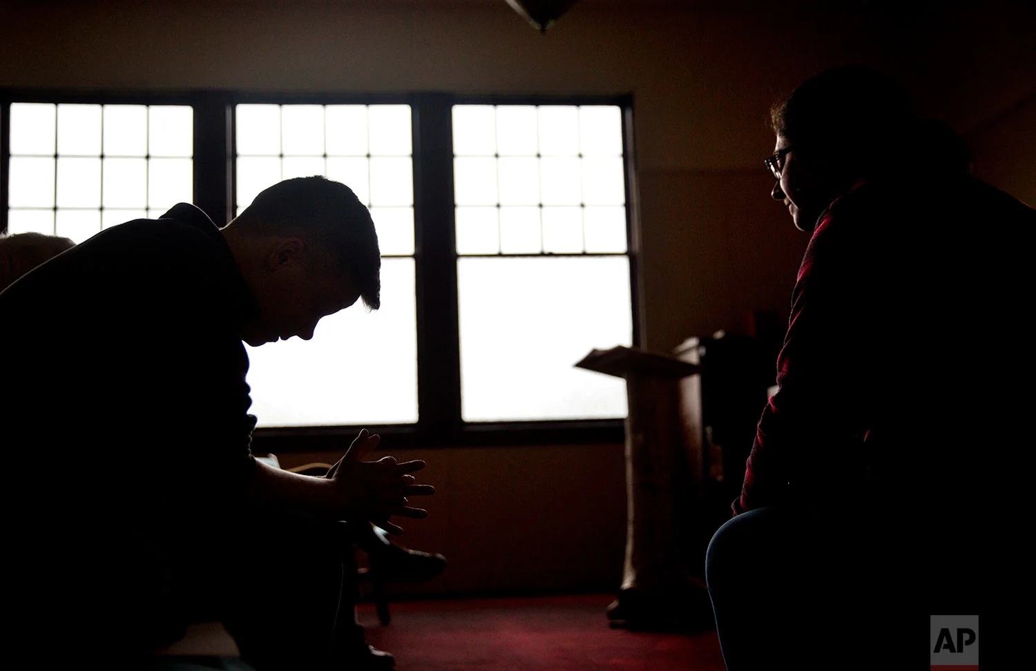Aaron Scott, left, prays during a service conducted by Rev. Sarah Monroe, right, at Chaplains on the Harbor church in Westport, Wash., Thursday, June 15, 2017. "I don't think our politicians know how high the stakes are here, and after so many years have gone by with our situation still as devastated as it is, I don't know if they care," Monroe says. "I'm not sure how much worse it can get, and at the same time I'm afraid to see how much worse it can get." (AP Photo/David Goldman) 