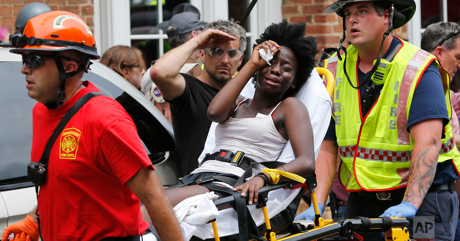  Rescue personnel help an injured woman after a car ran into a large group of protesters after an white nationalist rally in Charlottesville, Va., Saturday, Aug. 12, 2017.  The nationalists were holding the rally to protest plans by the city of Charl