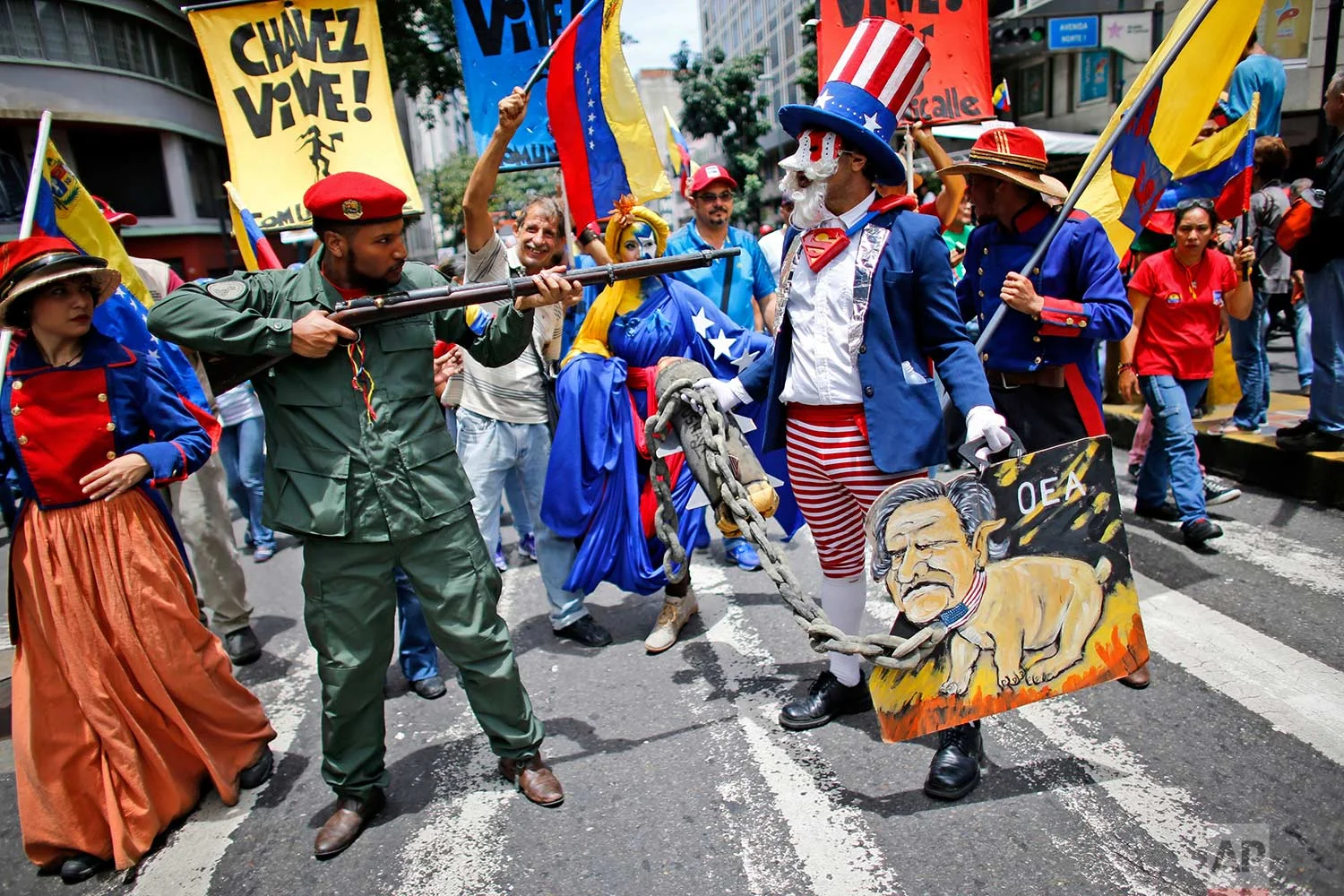 Government supporters perform a parody involving a Venezuelan militia member confronting Uncle Sam, symbolizing the U.S. government, during an anti-imperialist march to denounce U.S. President Donald Trump's talk of a "military option" for resolving the country's political crisis, in Caracas, Venezuela, Monday, Aug. 14, 2017. (AP Photo/Ariana Cubillos)