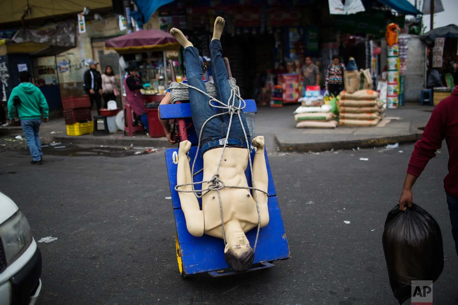 A loader or "cargador" carries a mannequin on his dolly at the Gamarra market, one of Latin America's largest and busiest textile markets, in Lima, Peru, Monday, Aug. 14, 2017. (AP Photo/Rodrigo Abd)