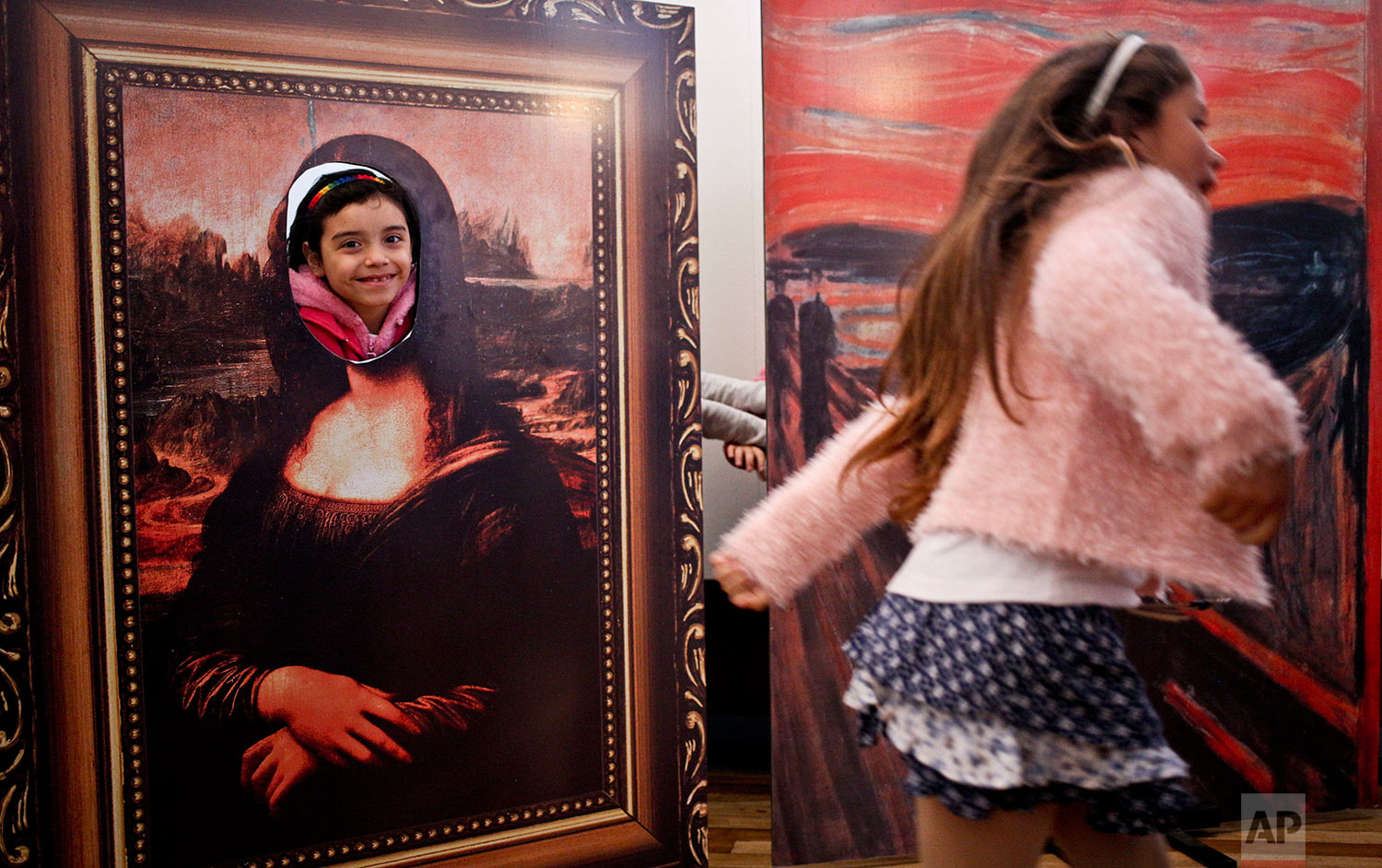  In this Aug. 20, 2016 photo, transgender girls Selenna, right, and Genesis who poses inside a Mona Lisa painting, play at the Artequin museum during celebrations marking Transgender Children's Day in Santiago, Chile. Families of trans children are d