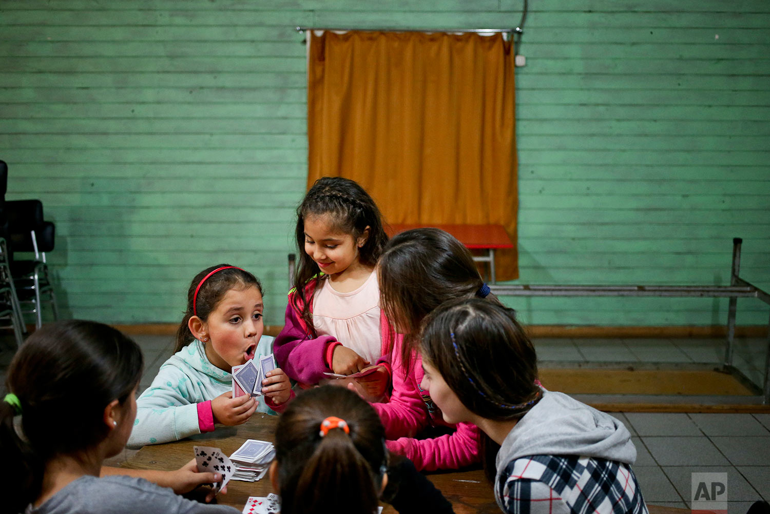  In this June 30, 2017 photo, transgender girl Selenna, left, plays cards during a break with other girls during a dance class at her community center in Santiago, Chile. Selenna's mother, Evelyn Silva, said she struggled to find a school that would 
