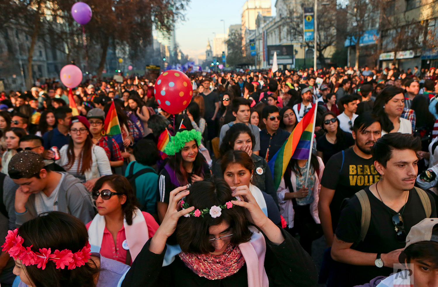  In this July 1, 2017 photo, Angela, below center, places a crown of flowers on her head as she attends a Gay Pride march alongside other transgender children in Santiago, Chile. The transgender children at the parade had socially transitioned to the
