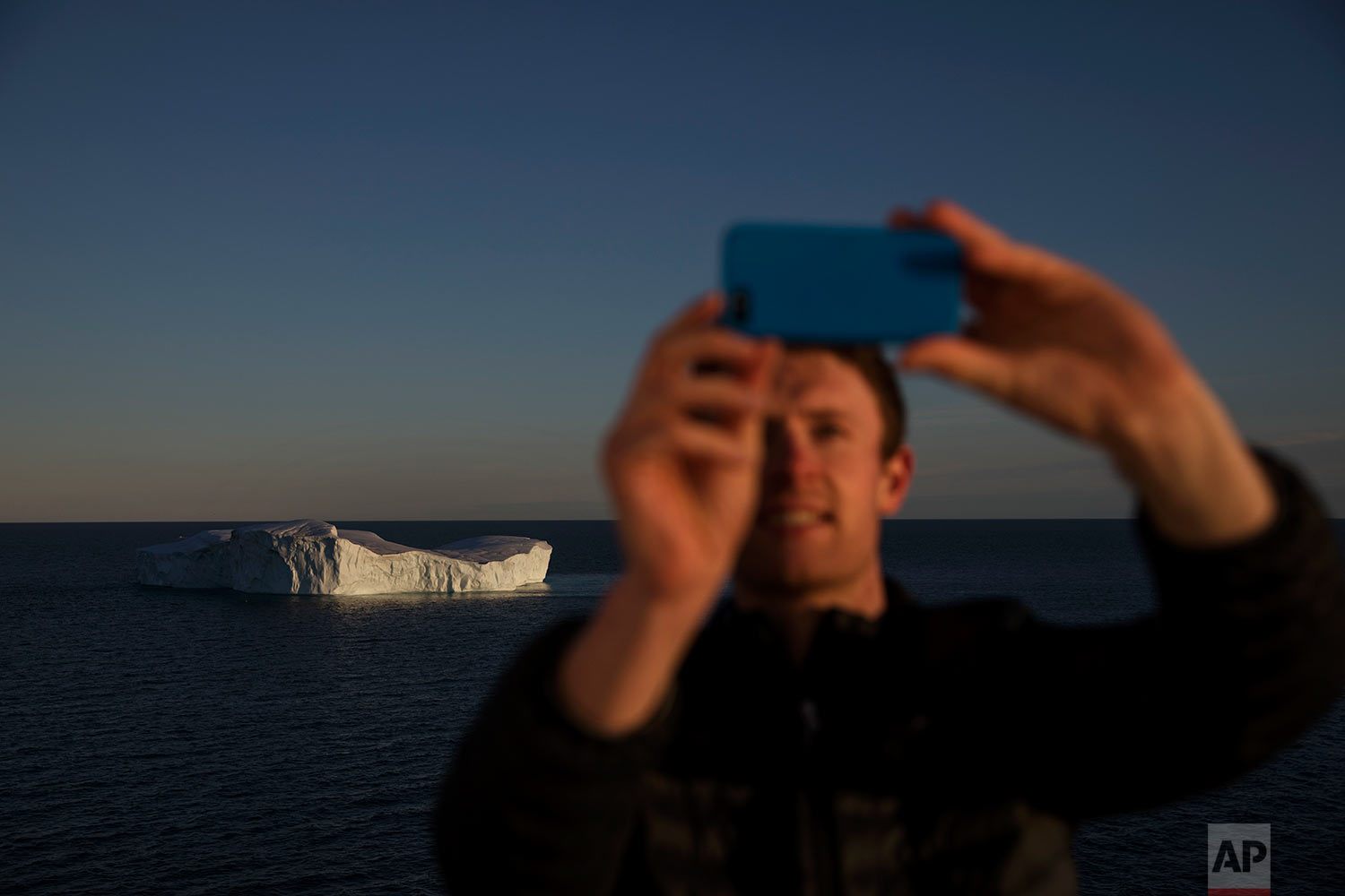  Researcher Scott Joblin takes a selfie while passing an iceberg floating in Baffin Bay in the Canadian Arctic Archipelago while aboard the Finnish icebreaker MSV Nordica, Tuesday, July 25, 2017.(AP Photo/David Goldman) 