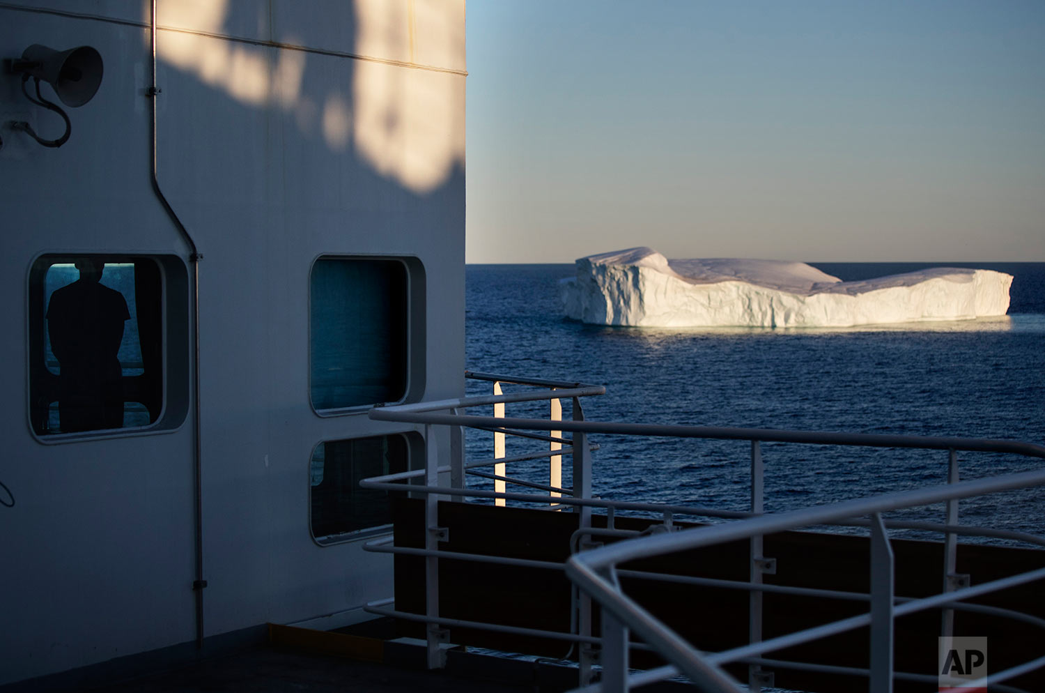  Trainee David Kullualik, left, looks out a window of the Finnish icebreaker MSV Nordica at an iceberg floating in Baffin Bay in the Canadian Arctic Archipelago, Tuesday, July 25, 2017. (AP Photo/David Goldman) 