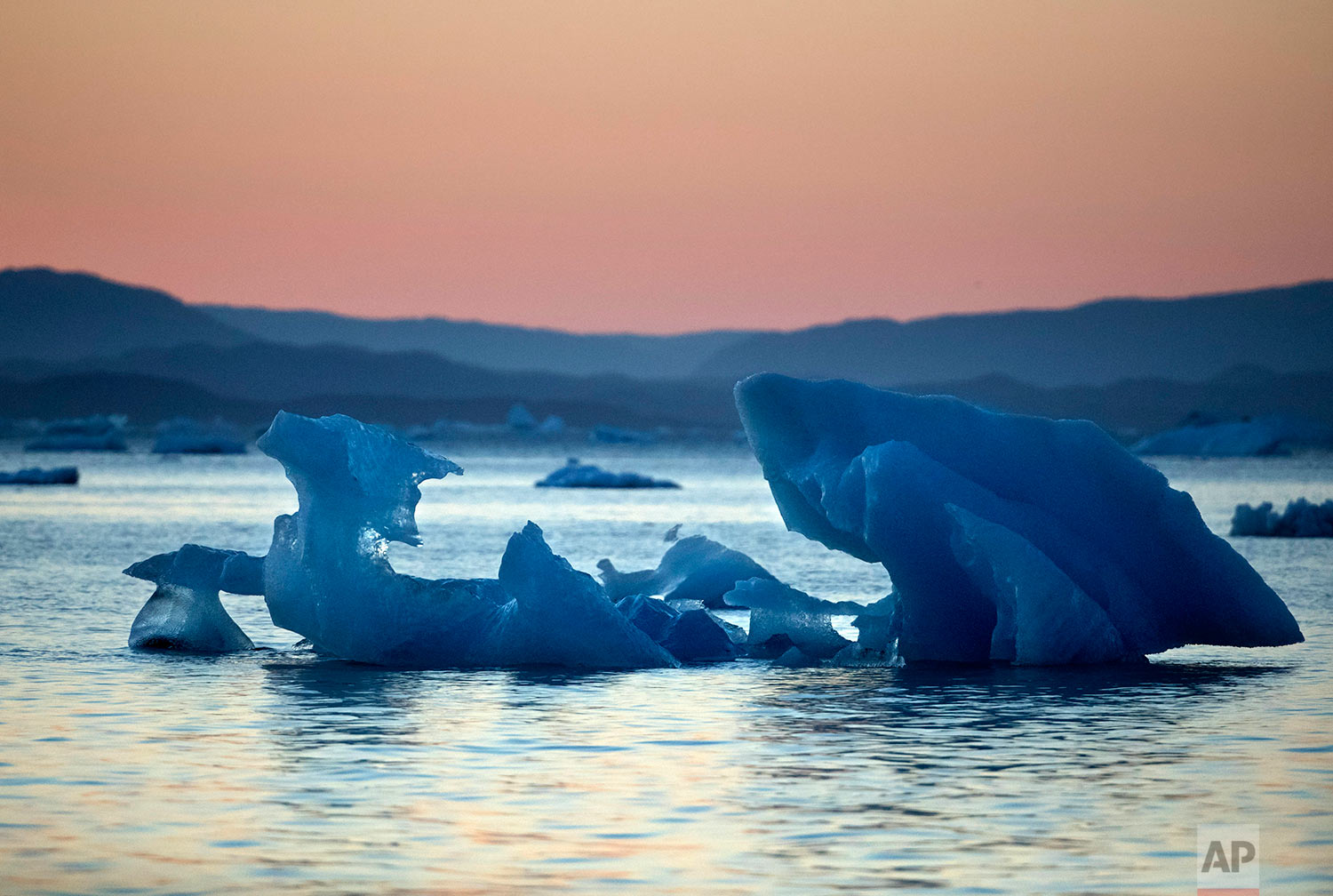  The suns sets as an iceberg floats in the Nuup Kangerlua Fjord near Nuuk in southwestern Greenland, Tuesday, Aug. 1, 2017. &nbsp;(AP Photo/David Goldman) 