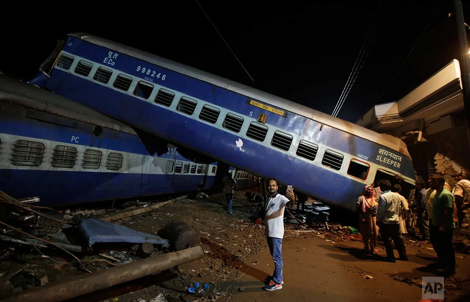 A man takes a selfie photo near the upturned coaches of the Kalinga-Utkal Express after an accident near Khatauli, in the northern Indian state of Uttar Pradesh, India, Sunday, Aug. 20, 2017. (AP Photo/Altaf Qadri)