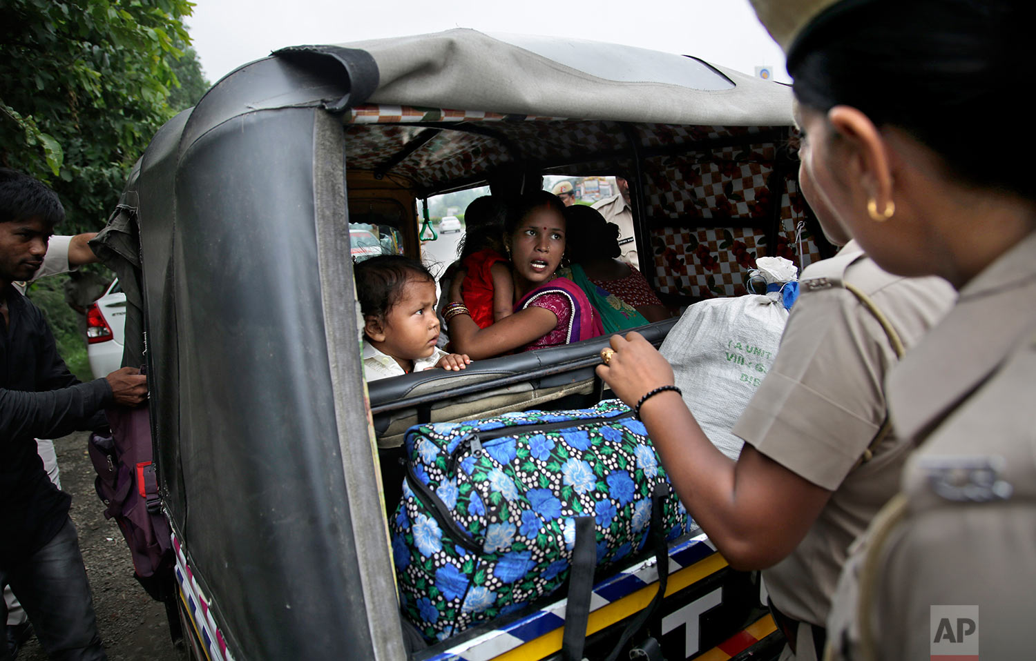  Indian policewomen question a woman passenger in an auto rickshaw as they check for supporters of the Dera Sacha Sauda sect near Panchkula, India, Thursday, Aug. 24, 2017. (AP Photo/Altaf Qadri) 