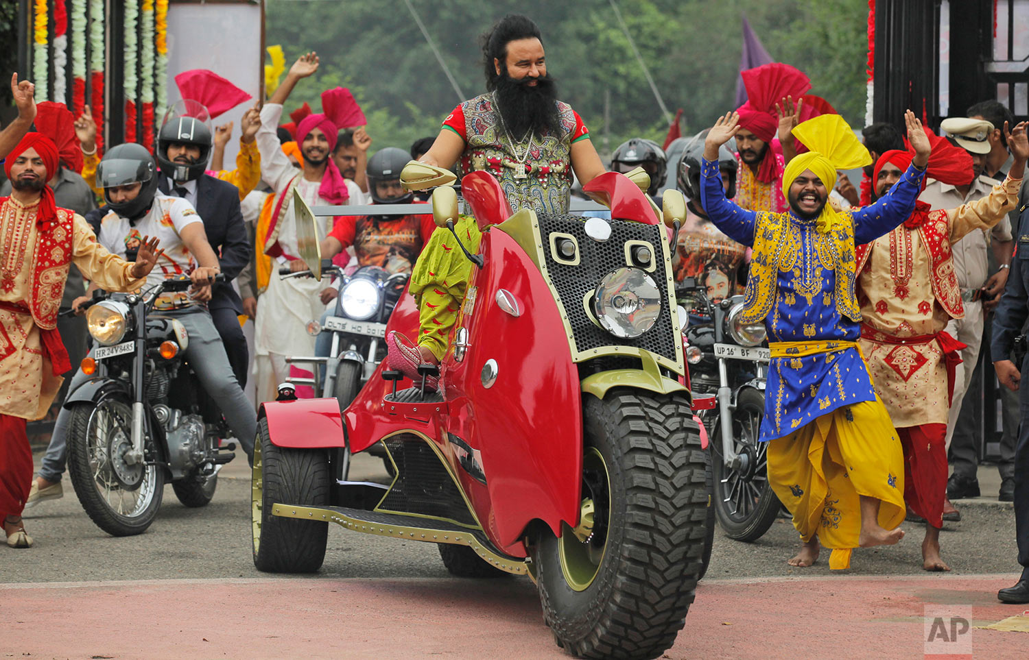  In this Wednesday, Oct. 5, 2016 photo, Indian spiritual guru, who calls himself Dr. Saint Gurmeet Singh Ram Rahim Insan, rides a motorcycle as he arrives for a press conference ahead of the release of his new film "MSG: The Warrior Lion Heart," in N