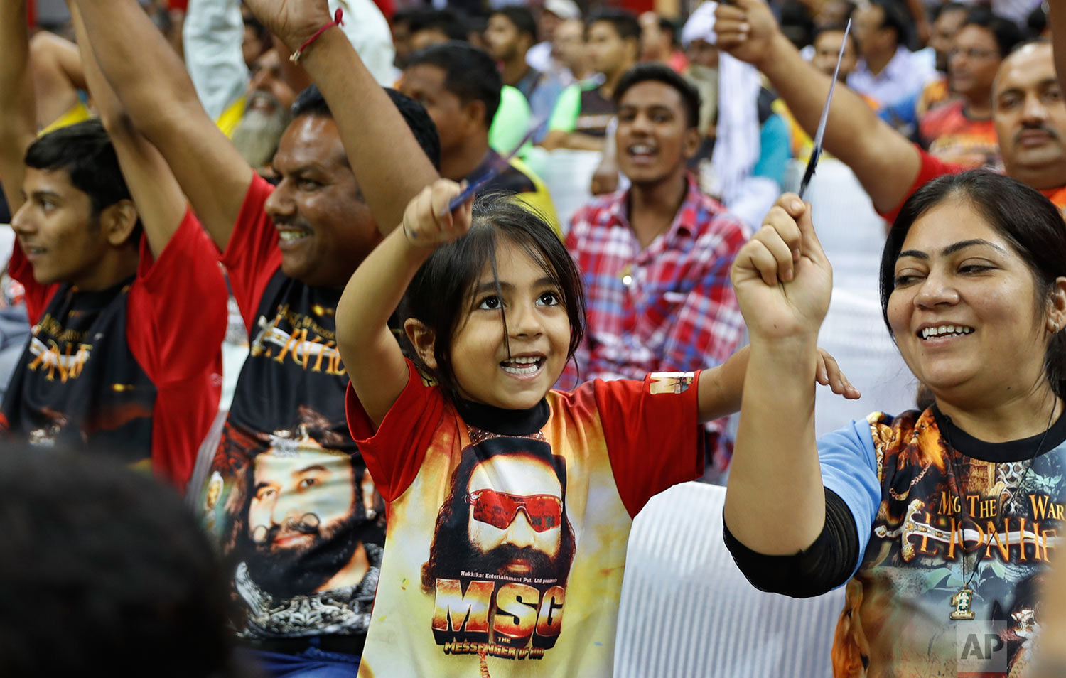  In this Oct. 5, 2016 photo, a child wears a T-shirt with a portrait of Indian spiritual guru, who calls himself Dr. Saint Gurmeet Singh Ram Rahim Insan, during a press conference ahead of the release of the guru's film "MSG, The Warrior Lion Heart,"